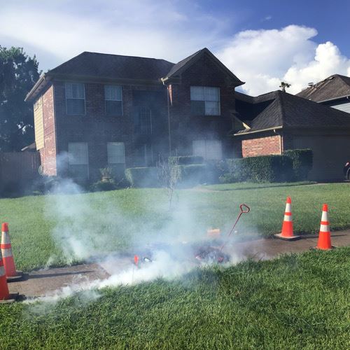 White smoke rises from a sidewalk