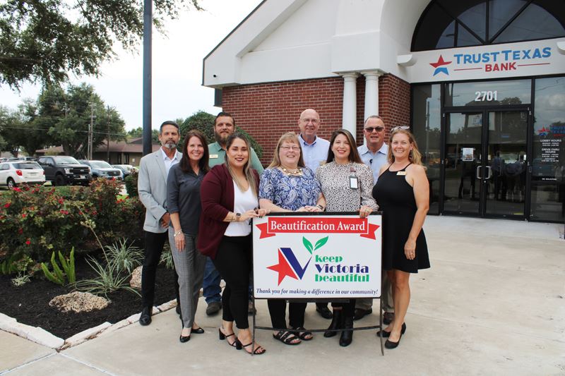 Group people outside bank with spacious flowerbed