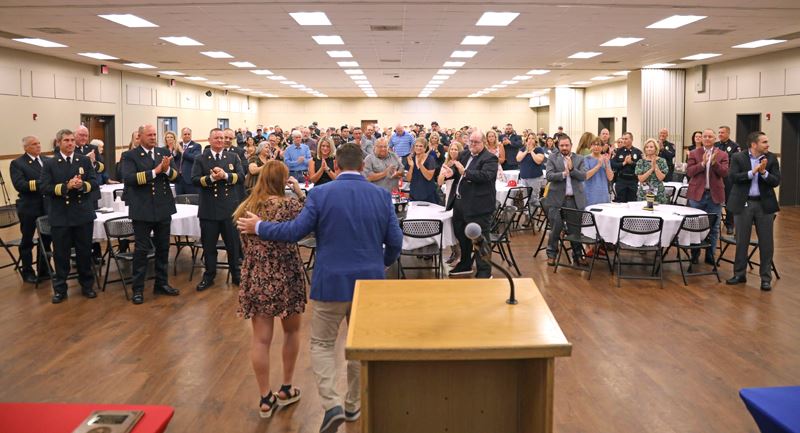 Chief Fox walks away from a podium in front of a crowd of cheering people