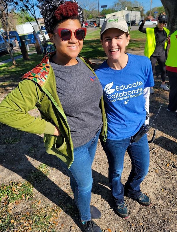 Two women pose for a photo outside