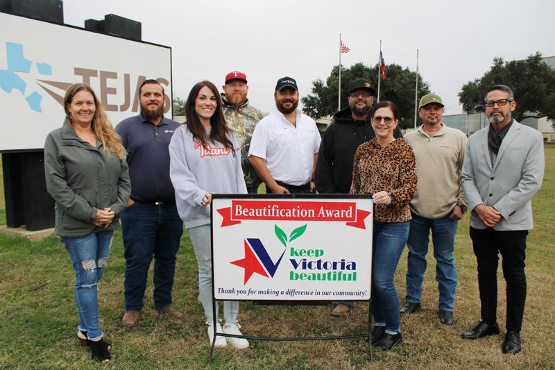 Group photo with KVB sign in front of Tejas sign