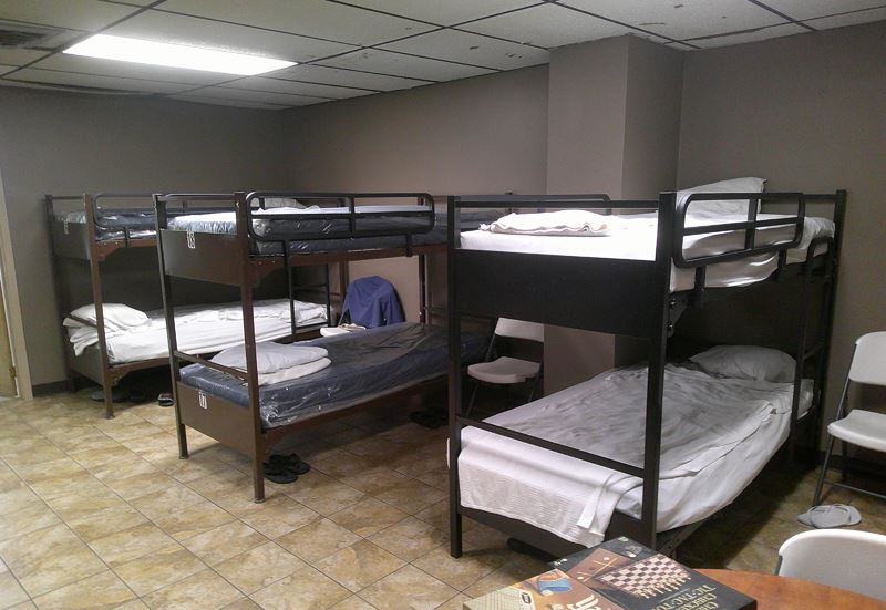 Rows of dorm bunk beds with ladders and railings