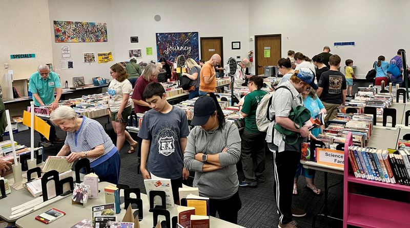 Crowd of people browsing makeshift shelves in the Victoria Public Library Bronte Room