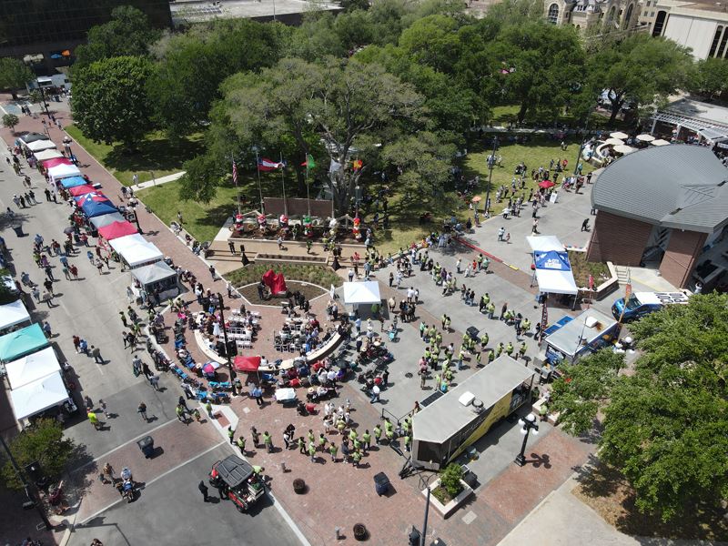 Aerial view of large crowd at outdoor festival in De Leon Plaza.
