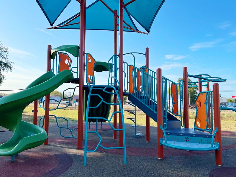 Brightly colored play structure with two slides and overhead shading