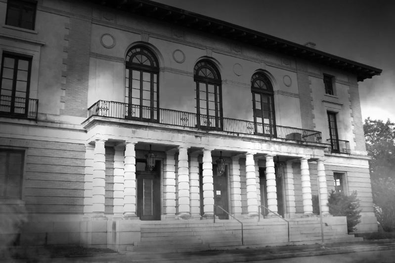 Historic old federal building with porch columns. Grayscale and fog effect applied to image.