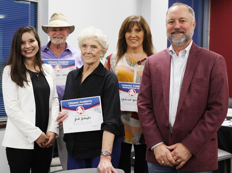 Group photo of five people. The three in the middle hold certificates. Opens in new window