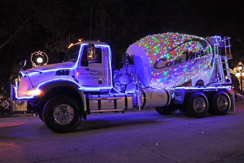 A concrete truck wrapped in Christmas lights