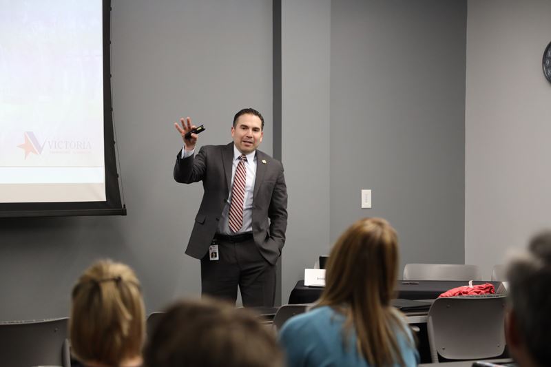 A man stands in front of a classroom and gives a presentation