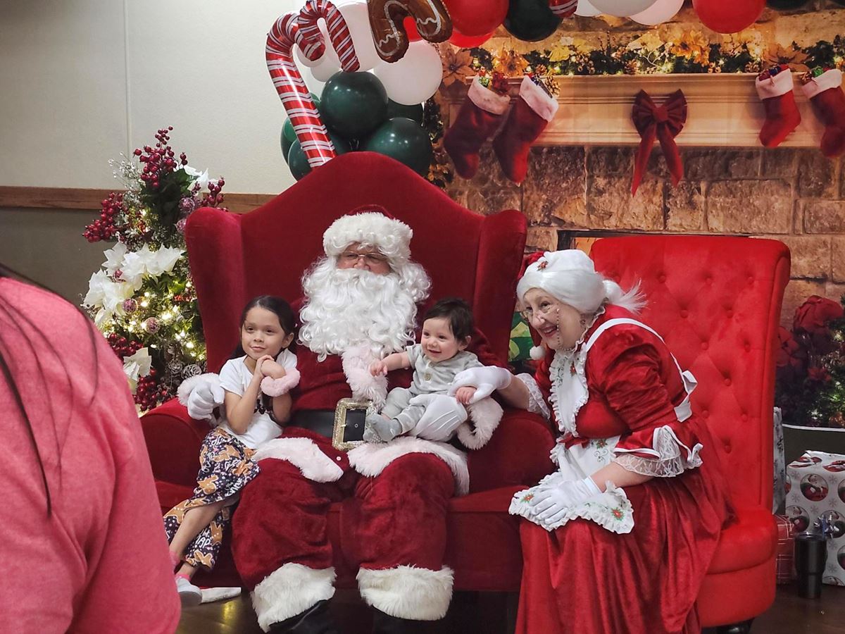 Photo of Santa and Mrs. Claus with a young girl and a baby