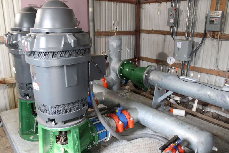 Two motors and large piping inside a shed.