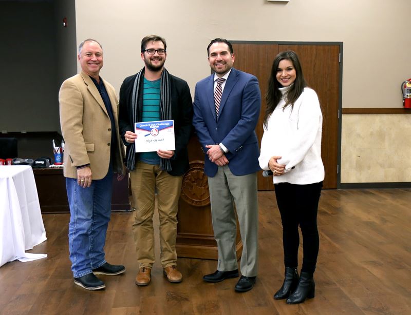 Group photo of four people. One holds a certificate with a Citizens Academy logo.