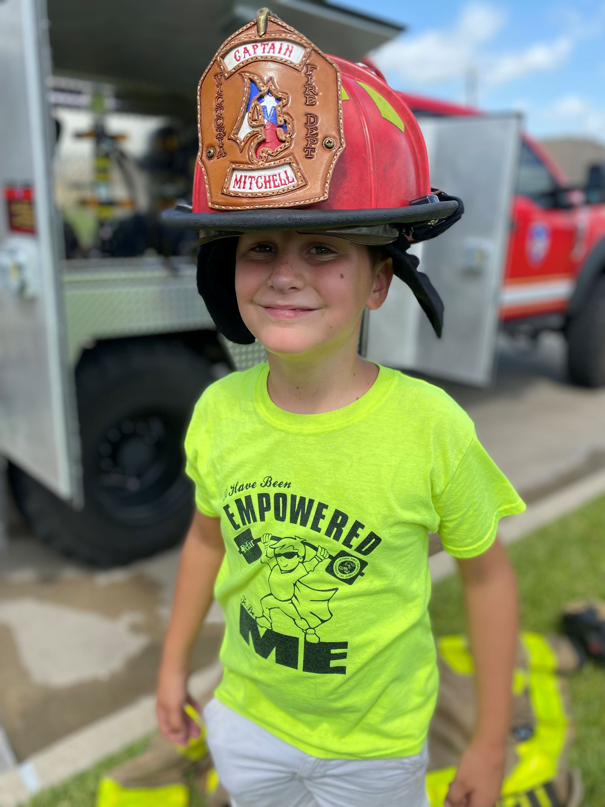 Child wearing a fire helmet.