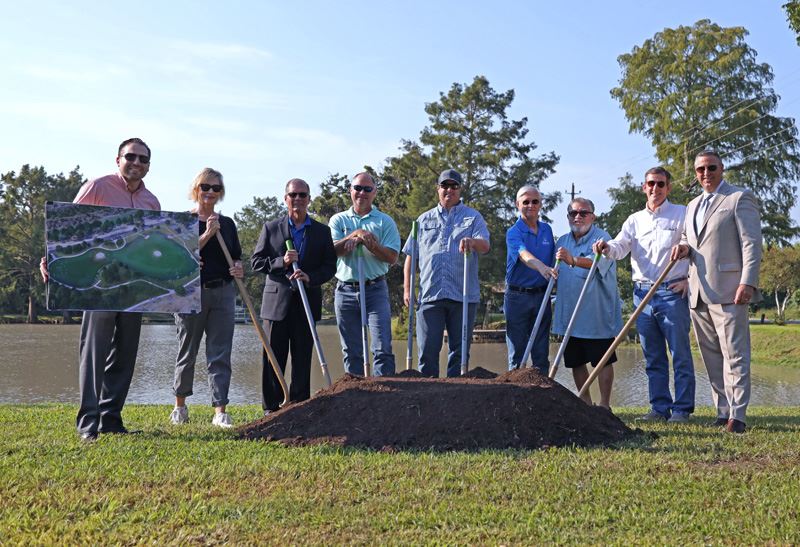 Group photo of people with ceremonial shovels dug into a pile of dirt.